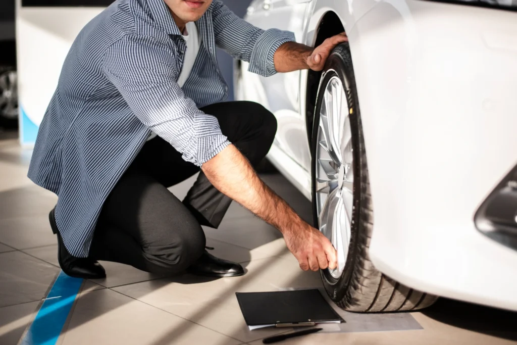 Used tyres singapore, A man wearing a polo shirt is inspecting a used car tyre