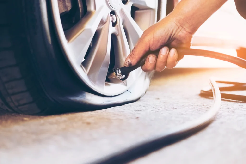 onsite tyre replacement, A tyre technician is inspecting a flat tyre for repair