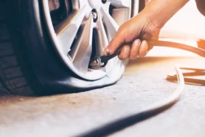 onsite tyre replacement, A tyre technician is inspecting a flat tyre for repair