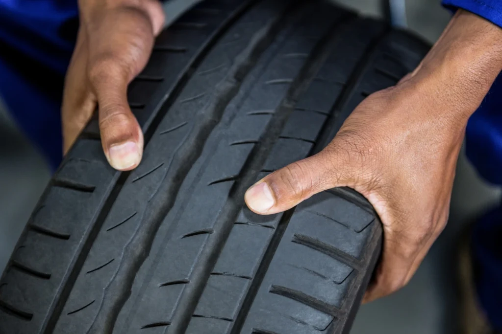 car tyres replacement, A man checking the threads of a new tyre